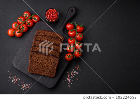 Delicious fresh brown bread with grains and seeds sliced on a wooden cutting board 102224552