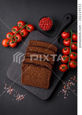 Delicious fresh brown bread with grains and seeds sliced on a wooden cutting board 102224553