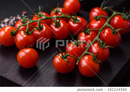 Delicious fresh cherry tomatoes on a twig with spices and herbs 102224560