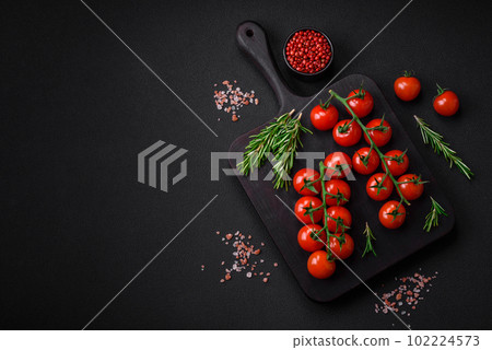 Delicious fresh cherry tomatoes on a twig with spices and herbs 102224573