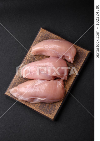 Pieces of raw chicken or turkey fillet with salt, spices and herbs Pieces of raw chicken or turkey fillet with salt, spices and herbs 102224580