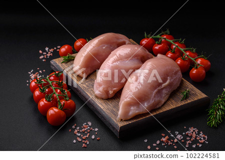 Pieces of raw chicken or turkey fillet with salt, spices and herbs 102224581