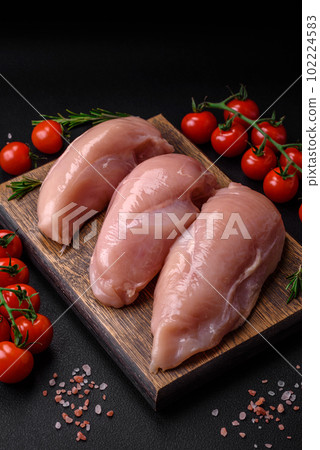 Pieces of raw chicken or turkey fillet with salt, spices and herbs Pieces of raw chicken or turkey fillet with salt, spices and herbs 102224583