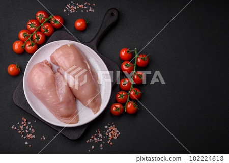 Pieces of raw chicken or turkey fillet with salt, spices and herbs 102224618