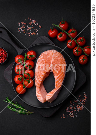 Fresh raw salmon steak with spices and herbs prepared for grilled baking 102224639