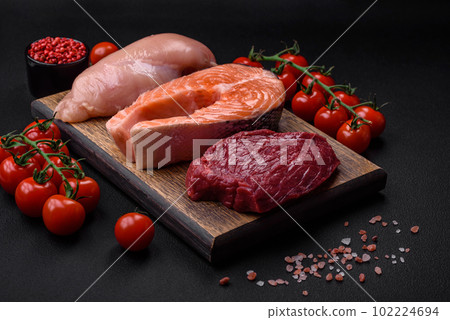 Chicken or turkey fillet, raw beef steak and salmon steak with spices and herbs Chicken or turkey fillet, raw beef steak and salmon steak with spices and herbs 102224694