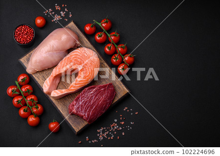 Chicken or turkey fillet, raw beef steak and salmon steak with spices and herbs 102224696