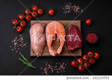 Chicken or turkey fillet, raw beef steak and salmon steak with spices and herbs Chicken or turkey fillet, raw beef steak and salmon steak with spices and herbs 102224701