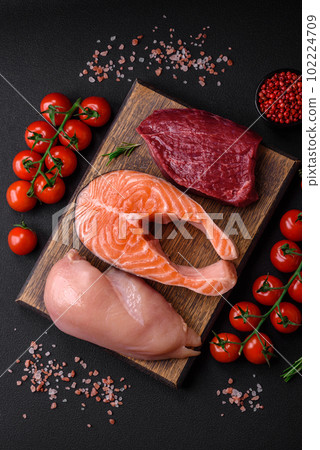 Chicken or turkey fillet, raw beef steak and salmon steak with spices and herbs 102224709