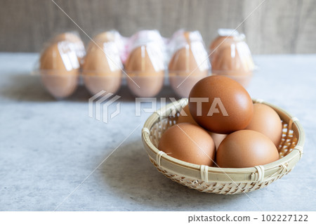 10 red eggs lined up in a plastic container and rose eggs in a colander 102227122