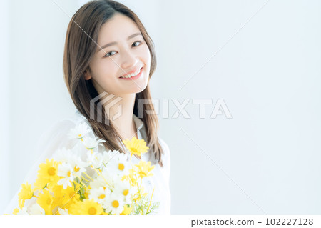 Young woman holding a bouquet in the living room Young woman holding a bouquet in the living room 102227128