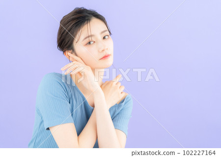 Young woman doing skin care with purple back 102227164