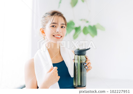 Woman drinking water after fitness 102227951