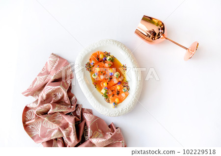 Salmon ceviche with mango gel on a white plate isolated Salmon ceviche with mango gel on a white plate isolated 102229518
