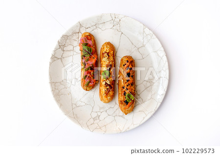 Eclairs with various fillings on a gray plate 102229573