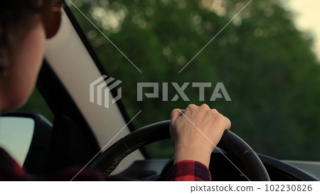 woman driving car turns steering wheel. driver hand wheel car. highway trip. track woman car. happy travel dream. young girl drives safely work car. road traffic transport SUV. woman driver steering 102230826
