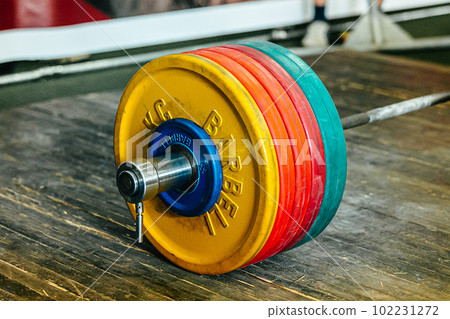 close-up heavy barbell on wooden platform at powerlifting competition 102231272