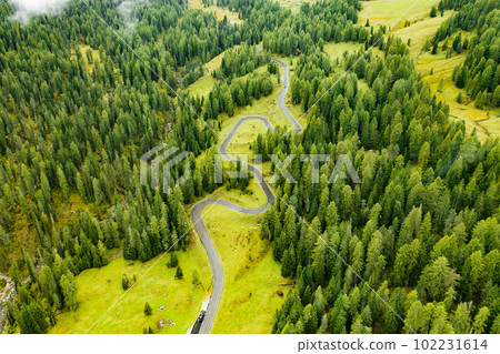 Snake Road winds across coniferous forests of Alpine mountains illuminated by sunlight. Giau Pass with famous sightseeing for tourists exploring virgin nature Snake Road winds across coniferous forests of Alpine mountains illuminated by sunlight. Giau Pass with famous sightseeing for tourists exploring virgin nature 102231614