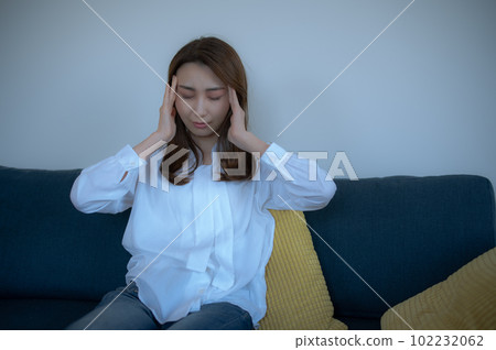 Woman feeling unwell with a headache Woman feeling unwell with a headache 102232062