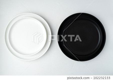 Empty ceramic plate, black and white on a concrete white background. Stylish tableware Empty ceramic plate, black and white on a concrete white background. Stylish tableware 102232133