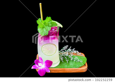 Lemon soda with purple syrup and mint on wooden plate isolated on black background 102232259