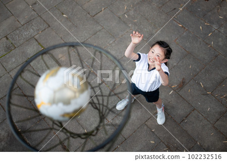 Child in gym clothes playing basketball Child in gym clothes playing basketball 102232516