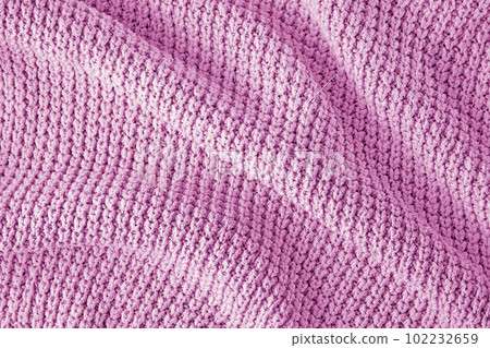 Pink knitted clothes in coarse knit with pleats and shadows as a background for the design Pink knitted clothes in coarse knit with pleats and shadows as a background for the design 102232659
