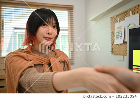 Smiling young business entrepreneur shaking hands with colleague. Agreement, new business and teamwork Smiling young business entrepreneur shaking hands with colleague. Agreement, new business and teamwork 102233054