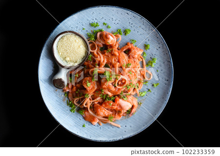 Pasta carbonara with sea food on blue plate isolated on black background side view Pasta carbonara with sea food on blue plate isolated on black background side view 102233359