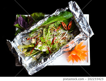 Pampus argenteus fish grilled in Vietnamese style with vegetables isolated on black background top view 102233423