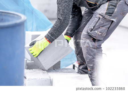 craftsman builds a house from concrete bricks craftsman builds a house from concrete bricks 102233868