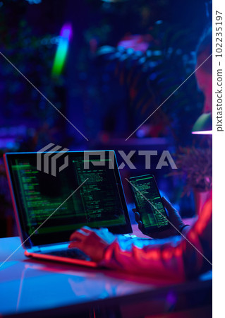 Seen from behind modern woman with laptop developing video game 102235197