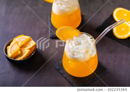 Dirty orange soda with whipped cream in glasses and orange slices on the table Dirty orange soda with whipped cream in glasses and orange slices on the table 102235364
