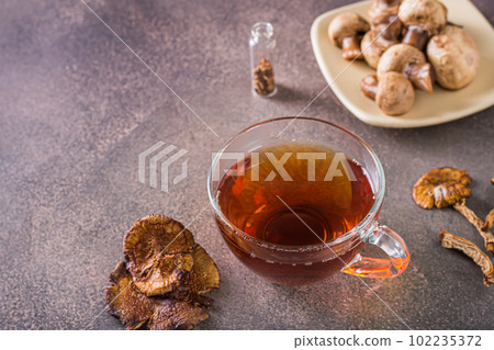 Homemade hot tea from dried mushrooms in a cup on the table 102235372