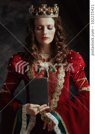medieval queen in red dress with book and crown medieval queen in red dress with book and crown 102235421