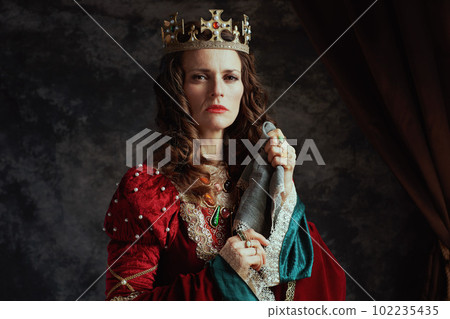 medieval queen in red dress with handkerchief and crown 102235435