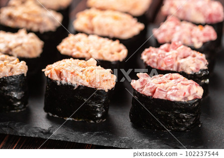 Set of Gunkan Maki Sushi with different types of fish salmon, scallop, perch, eel, shrimp and caviar on wooden table background. Sushi menu. Japanese food sushi set gunkans 102237544