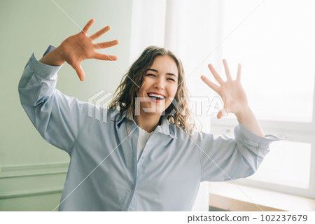 Joyful housewife having fun dancing in the living room, enjoying her free time at home while kids 102237679