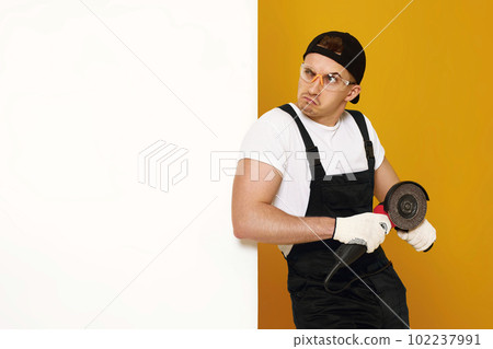 professional builder in work clothes works with cutting tool. 102237991