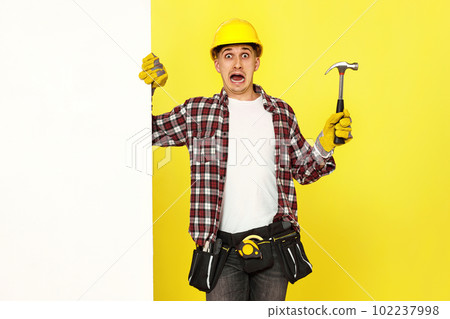 professional builder in work clothes in helmet holding hammer. 102237998
