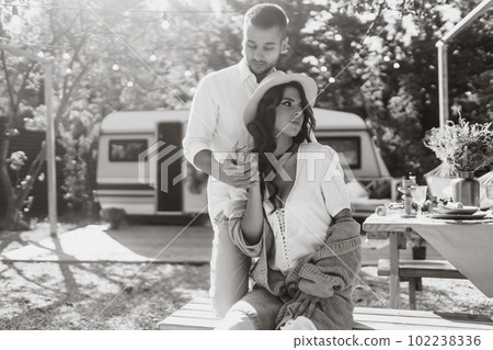 Beautiful wedding couple laugh and kiss relaxing in rv, camping in a trailer. Romantic moment. Beautiful wedding couple laugh and kiss relaxing in rv, camping in a trailer. Romantic moment. 102238336