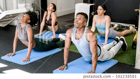 Group of multiethnic people doing stretching exercise on mats 102238581