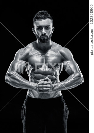 very muscular man posing with naked torso in studio 102238966
