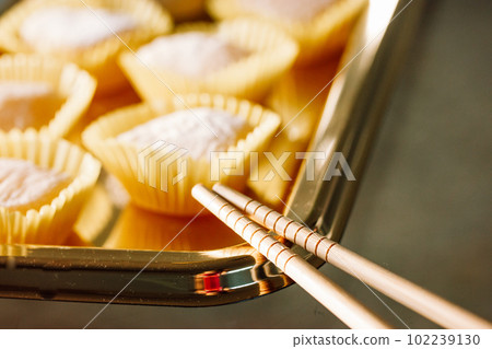 Yellow mango and lemon mochi mochies, wooden chopsticks on a golden tray top view. Asian food, sweets and delicacies. Japanese traditional confectionary ice cream made of rice flour dough. Soft focus. Yellow mango and lemon mochi mochies, wooden chopsticks on a golden tray top view. Asian food, sweets and delicacies. Japanese traditional confectionary ice cream made of rice flour dough. Soft focus. 102239130
