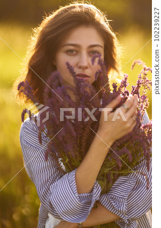 Portrait of a beautiful girl with a bouquet of lavender. Sunset light and beautiful sensuality. 102239227