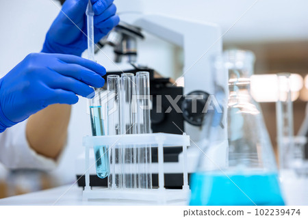 Researcher working in chemical laboratory, doctor in blue gloves, molecular biology investigation. 102239474