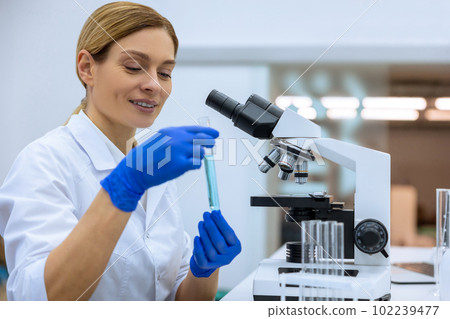 Attractive female scientist examining liquid in test tube in laboratory, doing DNA researching 102239477