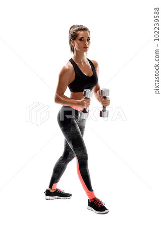 Strong woman exercising with dumbbells for arms. Photo of woman working out with dumbbells on white background. Strong woman exercising with dumbbells for arms. Photo of woman working out with dumbbells on white background. 102239588