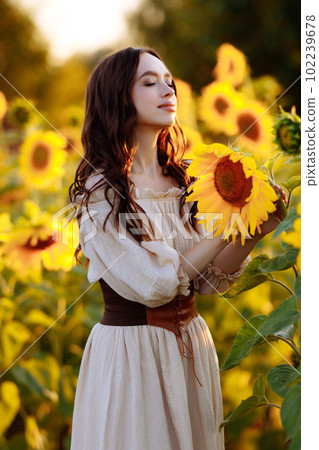 Beautiful woman in a dress in a field of sunflowers Beautiful woman in a dress in a field of sunflowers 102239678