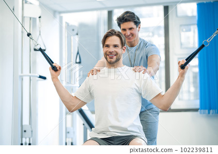 Physical therpaist working with the patient in a rehabilitation center 102239811